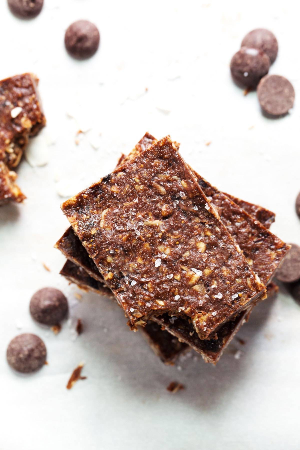 Sea Salt Dark Chocolate Bars stacked on each other near chocolate chips. 